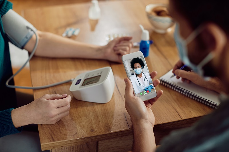 close up of couple measuring blood pressure and having video cal